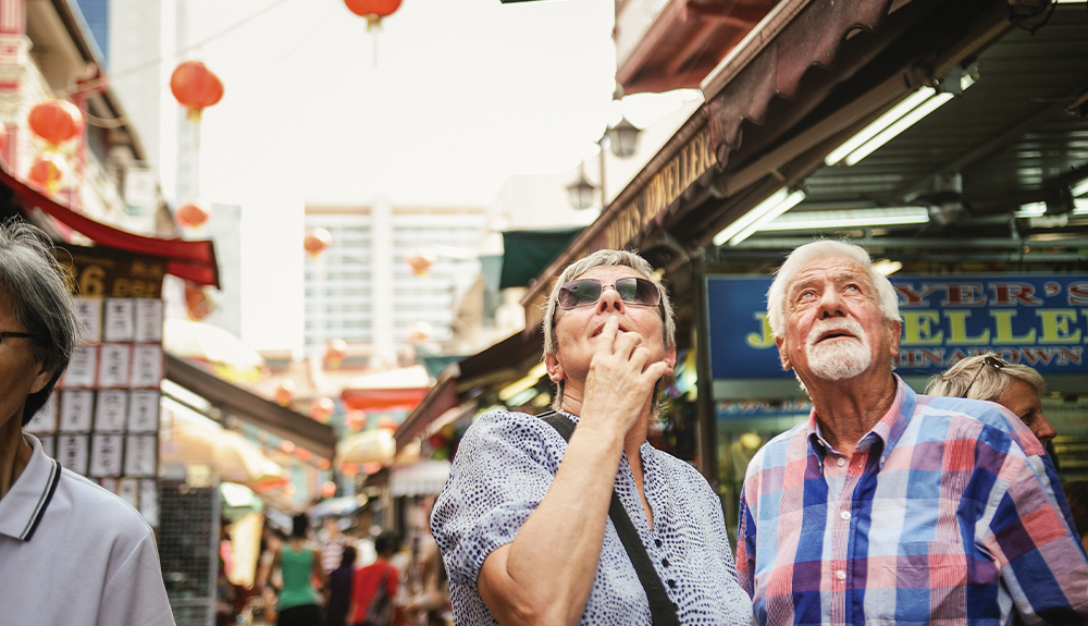 An older couple navigate a crowded market