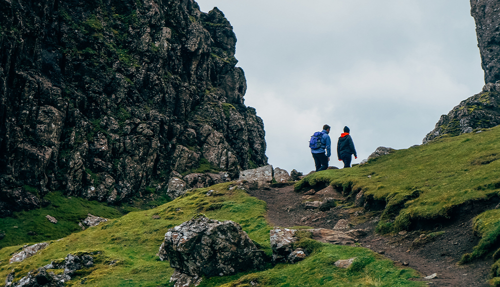 Travellers hike on a path up a hill