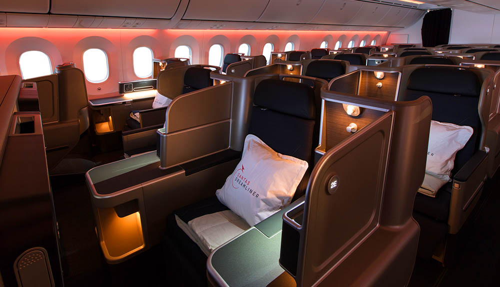 Large, luxurious seating pods with privacy barriers and pillows on the seat ready for relaxing on a Qantas Airways flight 