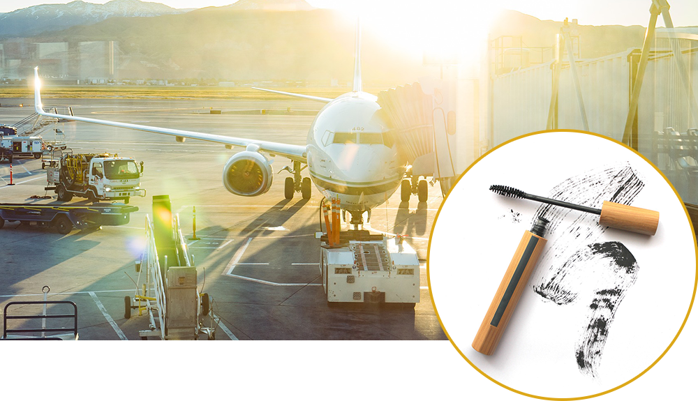 A product shot of a tube of mascara overlaid over a shot of an airplay on being loaded on the tarmack