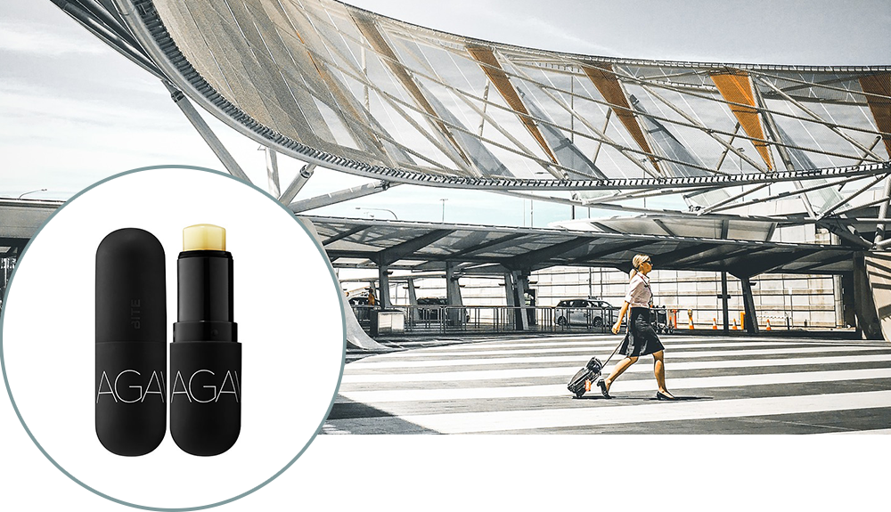 A shot of Bite Beauty Agave lip balm over a photo of a woman walking out of an airport, suitcase trailing behind her