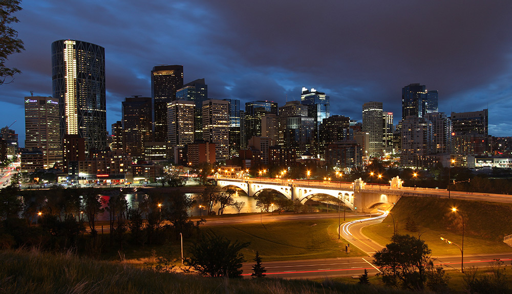 The Calgary cityscape seen in the evening, lights from the highway and high rise buildings glittering in the evening sky