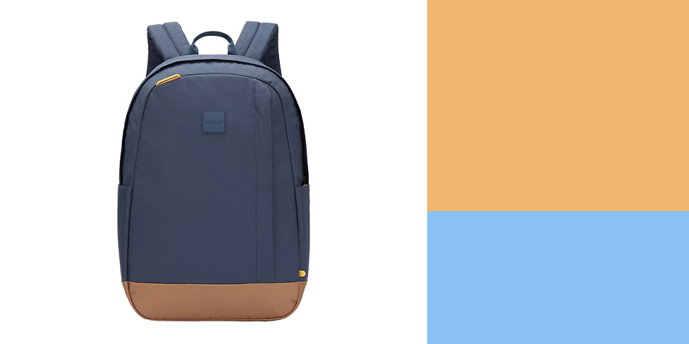 An image of the Pacsafe Go 25L Anti-Theft Backpack, a blue backpack with a brown bottom panel and small orange zippers on a plain white background.