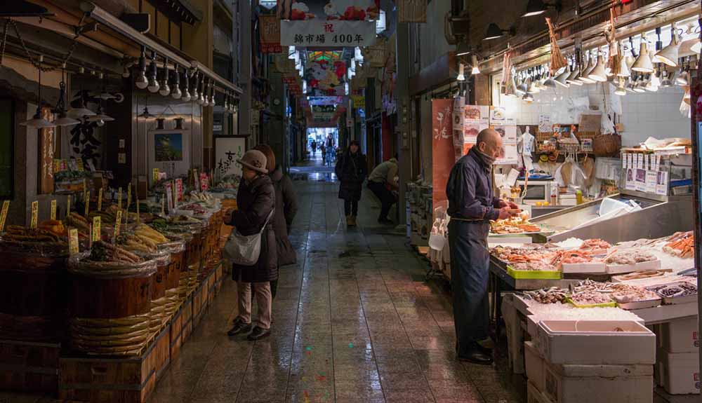  A shot shows the halls of Kyoto market, shoppers browsing the stalls