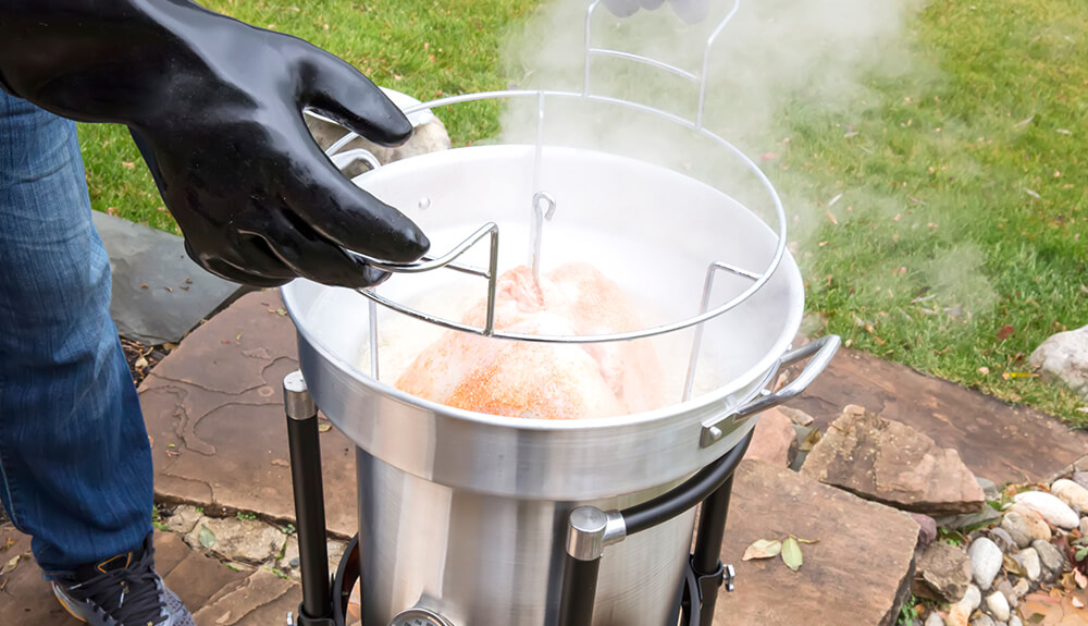 Person deep frying a turkey outside