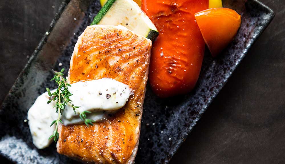 Salmon and vegetables served on a rectangular plate