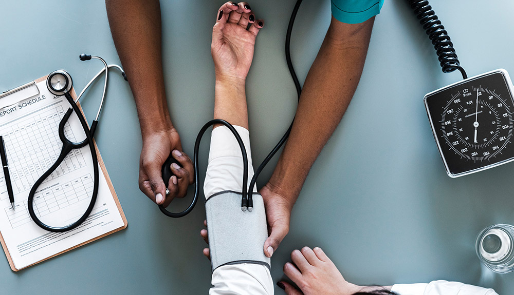 A medical professional checks a patient's blood pressure