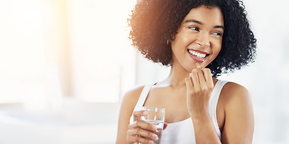 A woman prepares to take a vitamin