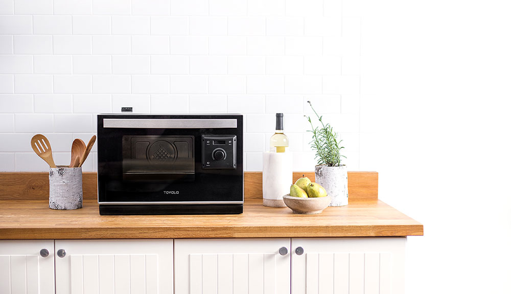 A smart oven that resembles a microwave on a kitchen counter top