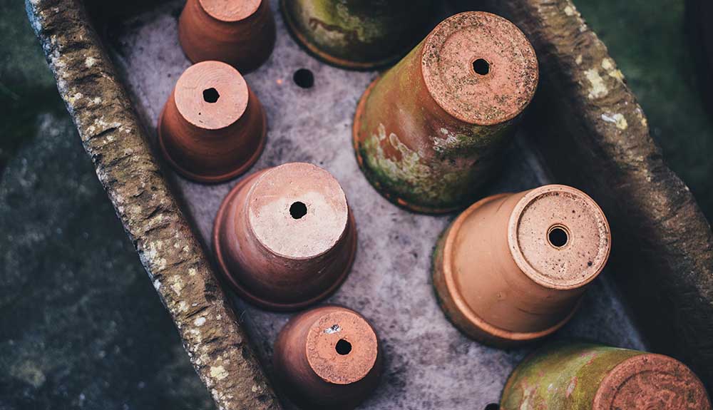 Rows of terracotta pots that are turned upside down to dry properly.