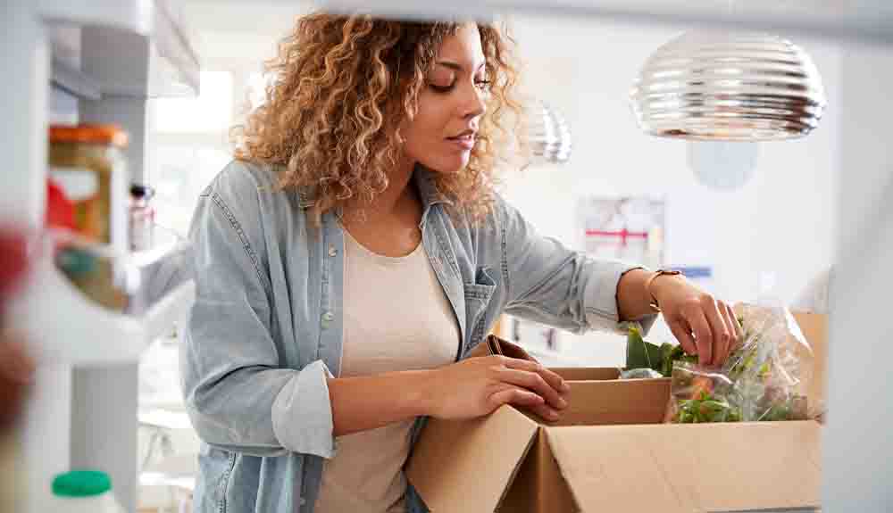 A woman opening a box in her home.