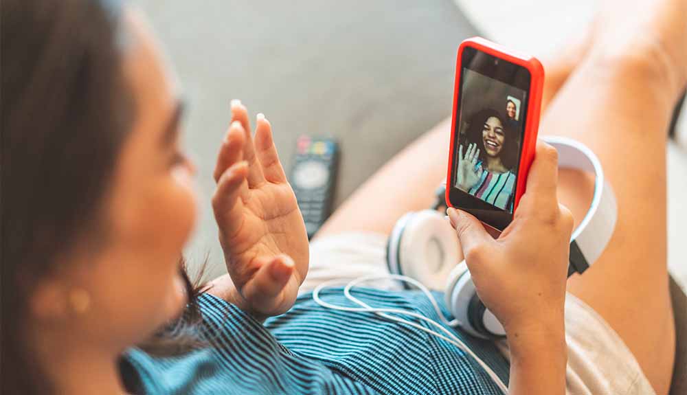 A woman is shown having a video chat on her phone