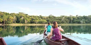 Two women paddle a canoe on a lake
