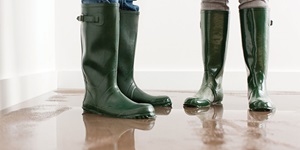Two people in rubber boots standing in a pool of water