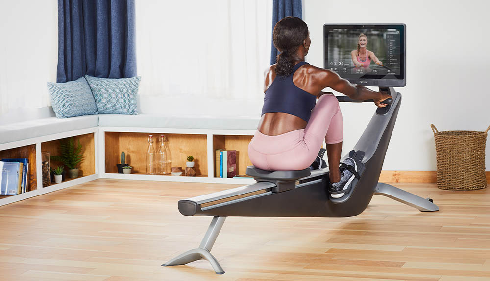 A woman exercises on the Hydrow rowing machine in her home