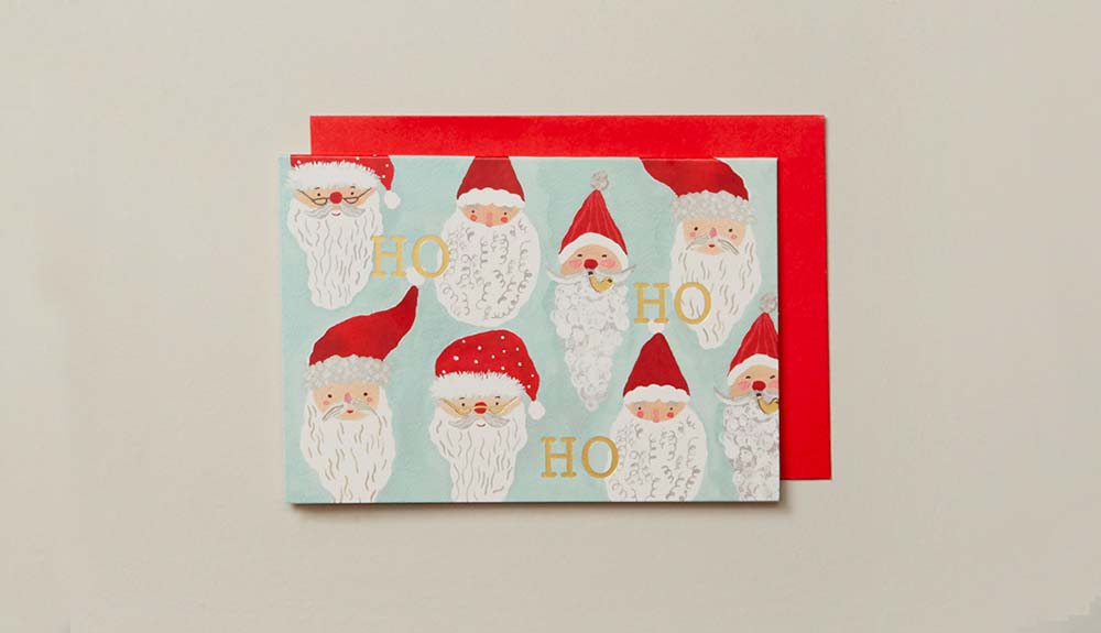 A Christmas card with multiple Santa Claus heads is shown