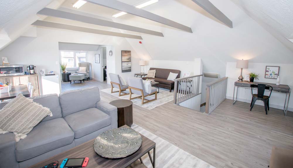 The Loft space is shown with multiple seating areas and a desk at the end of the room