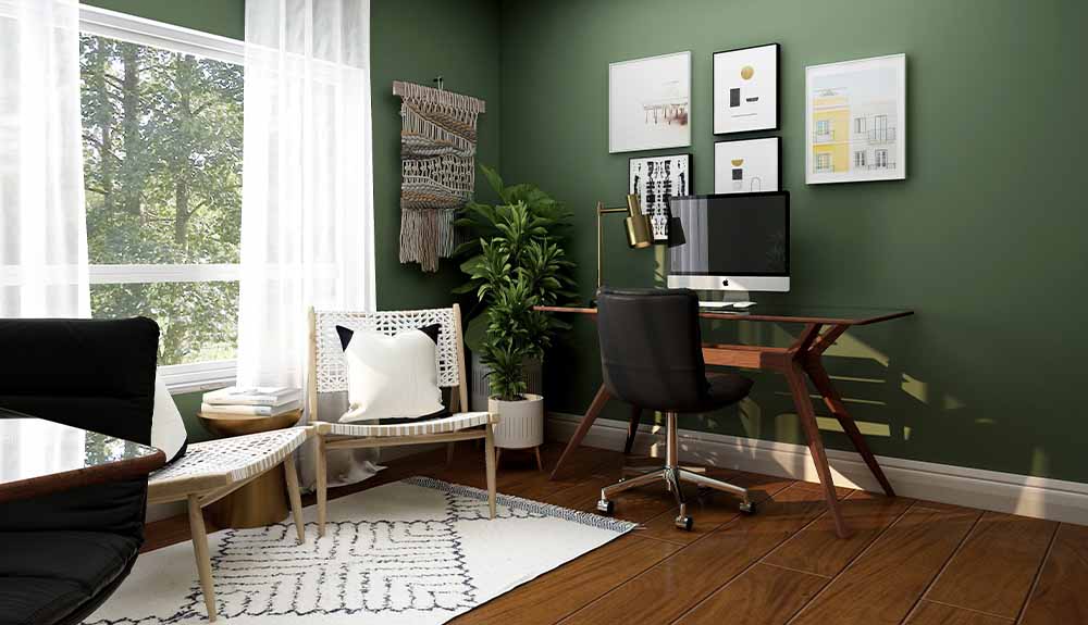 A computer and desk are shown set up within a living room with chairs