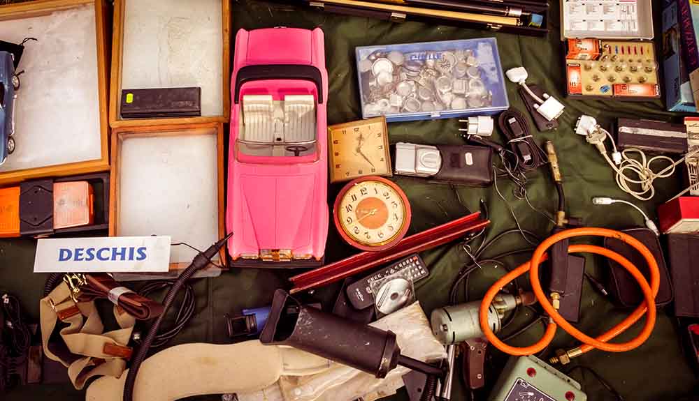 An assortment of knick knacks including old electronics, collectibles, wires, clocks and games