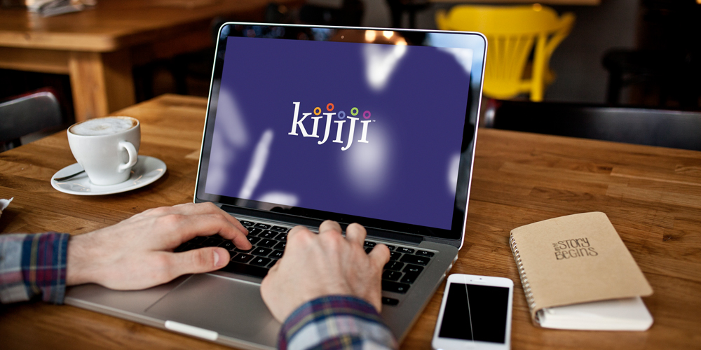 Hands are seen tapping on a laptop keyboard and on the laptop screen is the logo for Kijiji