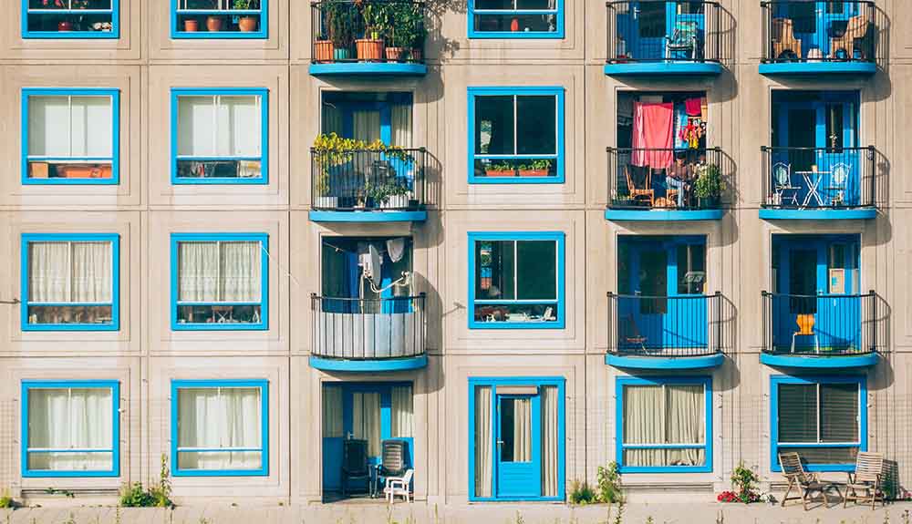 A brown building with bright blue windows and balconies