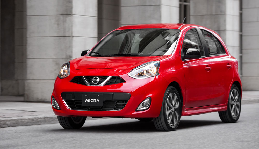 A red Nissan Micra is shown on a city street