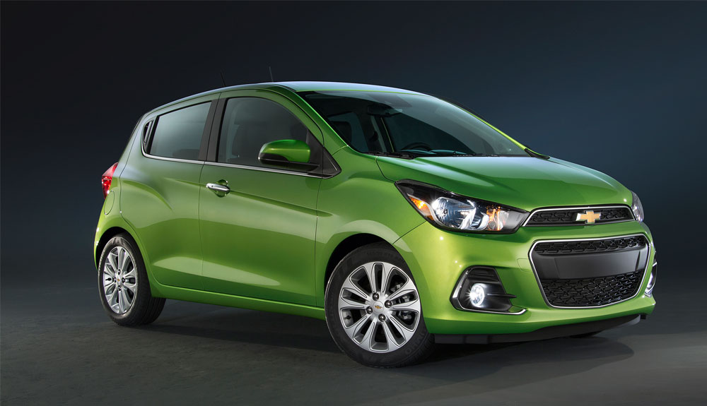 A green Chevy Spark is shown against a black background
