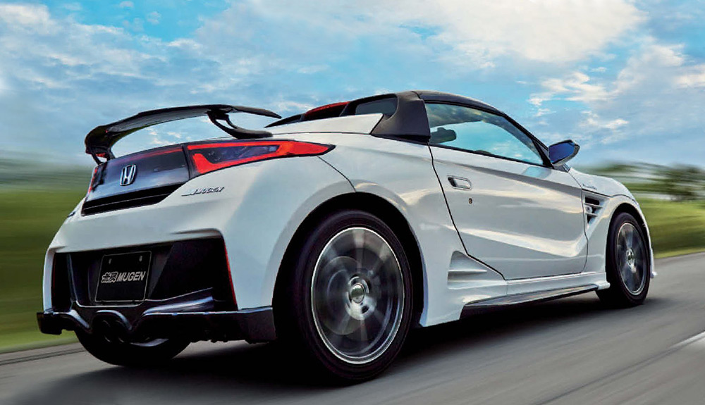 A white Honda S660 is shown on a country road