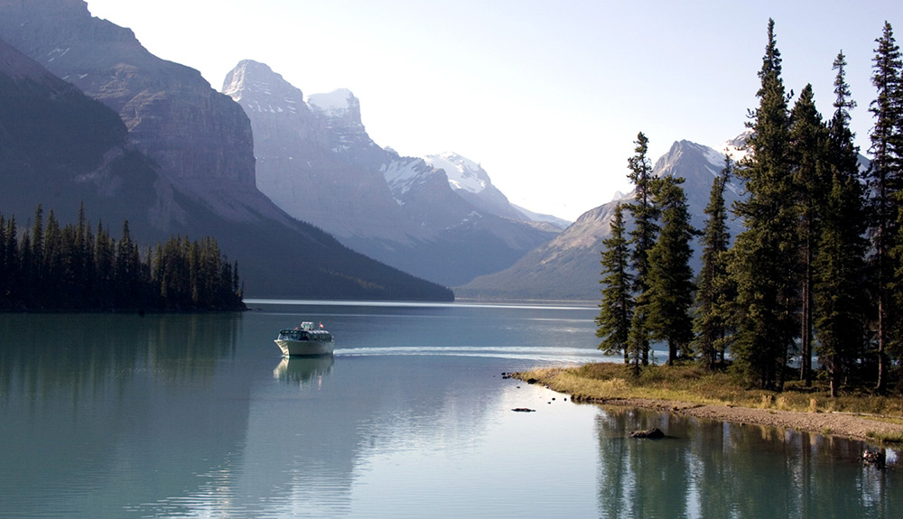 A cruise boat on tranquil Maligne Lake
