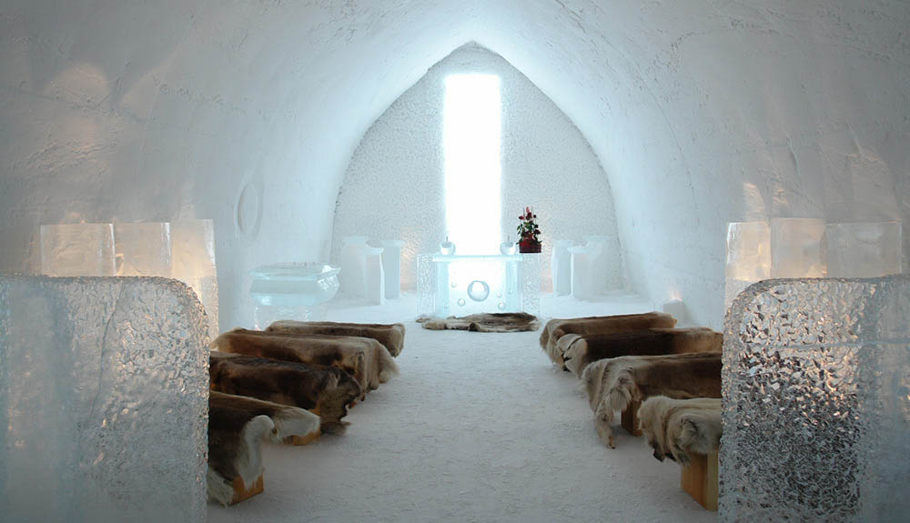 Small wooden beds with animal furs and clear furniture made of ice are seen inside the Finland's SnowCastle ice hotel