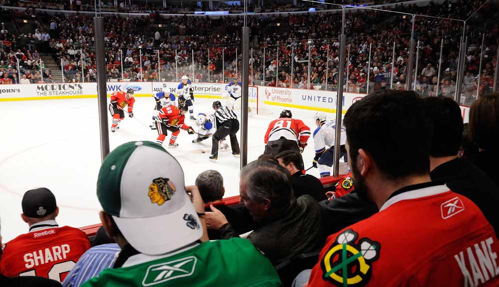 View through fans of faceoff during NHL's Chicago Blackhawks and St. Louis Blues
