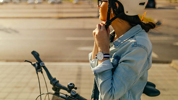 Female cyclist adjusting her helmet