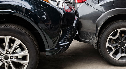 A black car hitting the rear bumper of a grey car