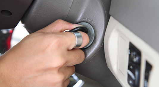 Person putting car key in ignition