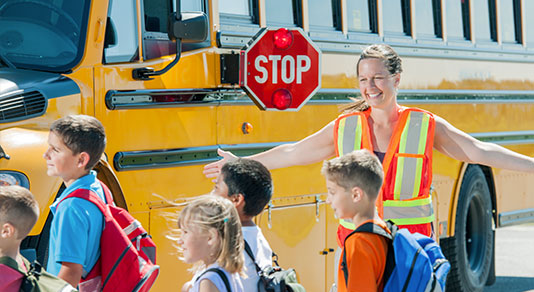 Kids crossing street in front of school bus
