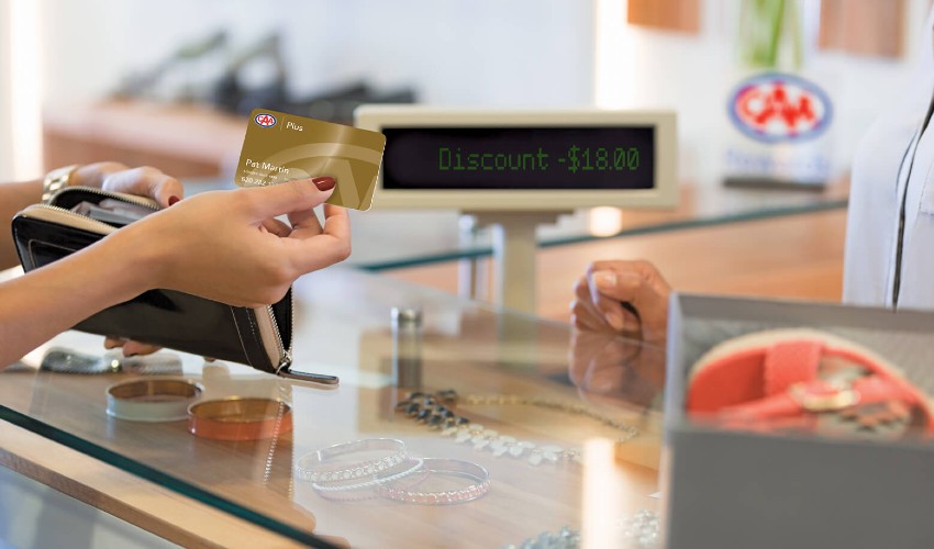 Woman handing over CAA Membership card at the point of sale.
