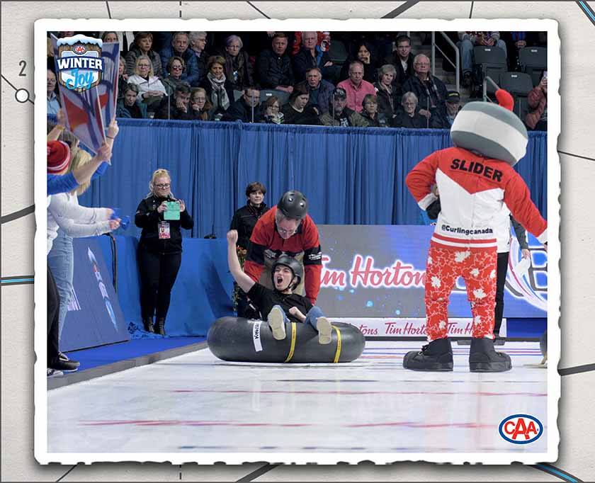 A person in an inflatable tube being pushed down a curling lane.