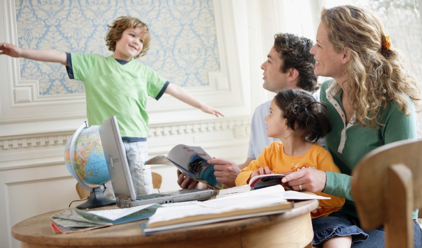 Family of four at a table planning a vacation.