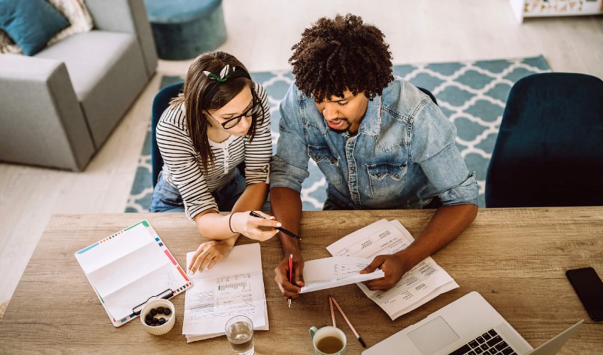 Young, multi-ethnic couple updating their finances.