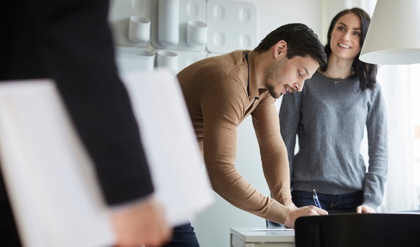 Woman and man in new home signing documents.