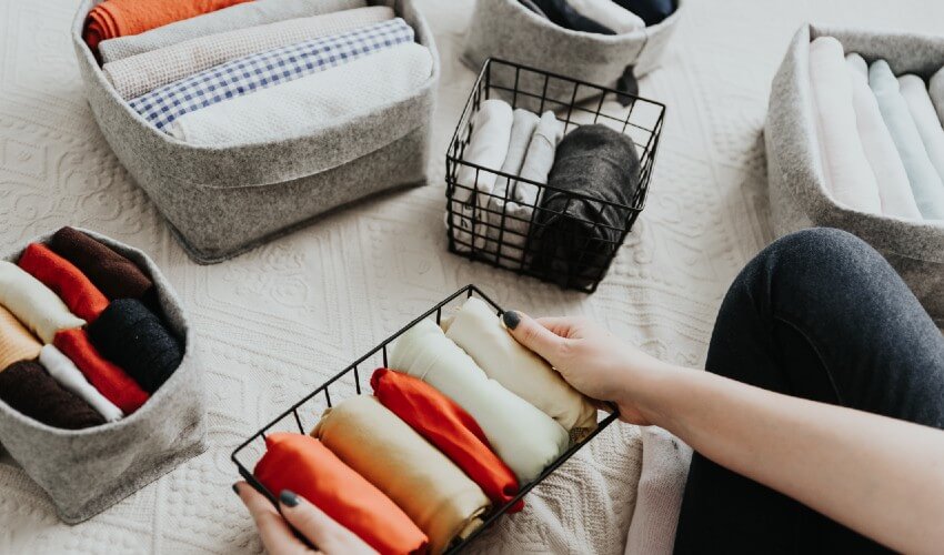 Woman organizing towels in baskets.