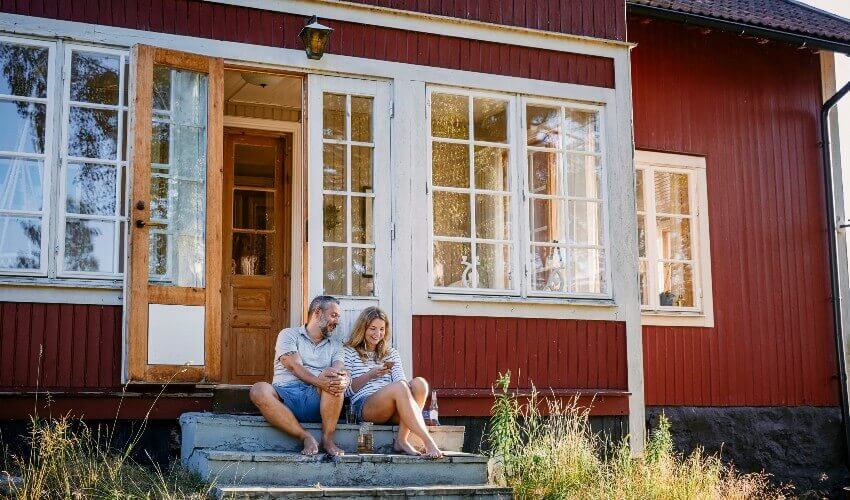Couple sitting on cottage stairs.