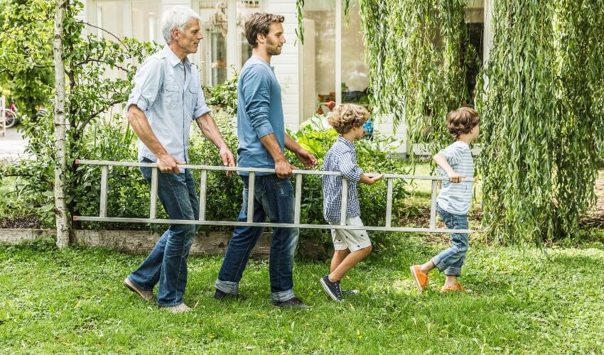 Grandpa father and sons carrying ladder.
