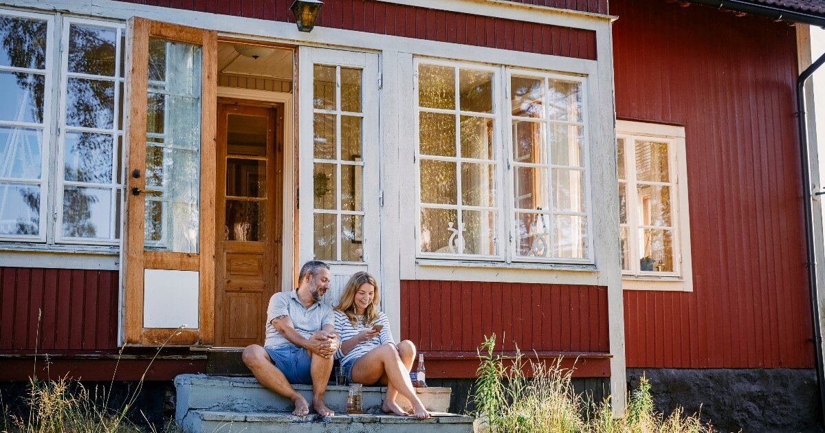 Couple sitting on cottage stairs.