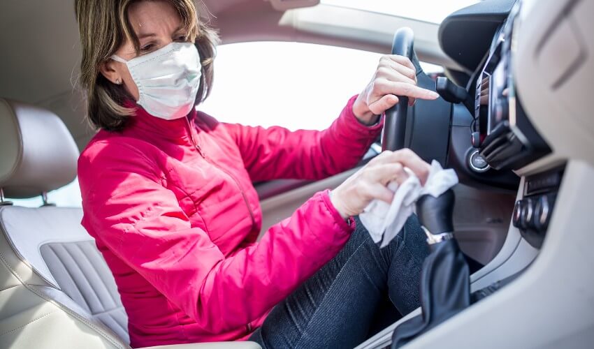 Woman using antibacterial wipe on gearshift