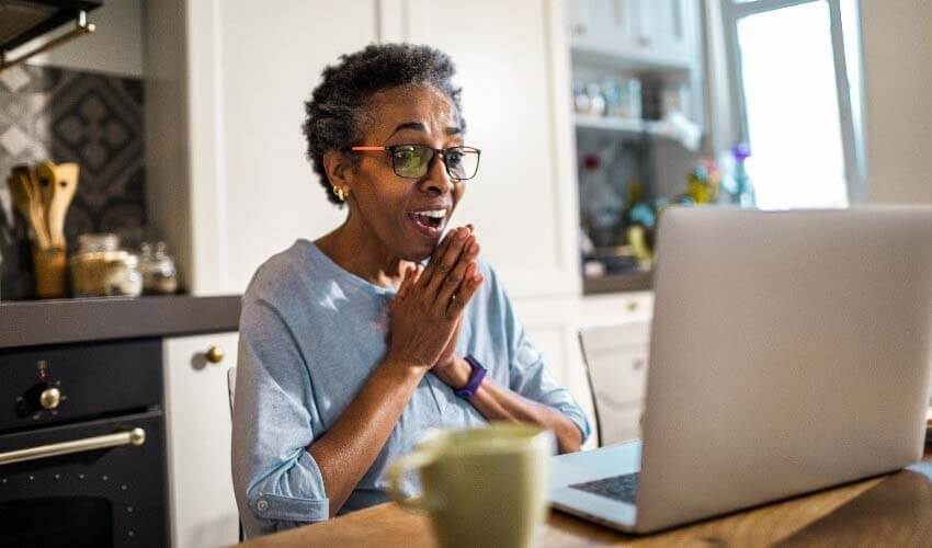 Mature woman looking at a laptop doing her finances.