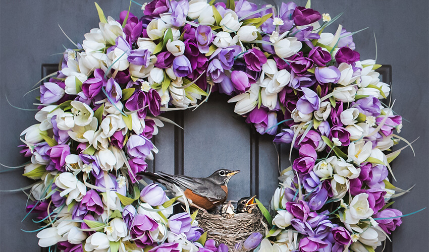 Purple and white flower wreath on grey door.