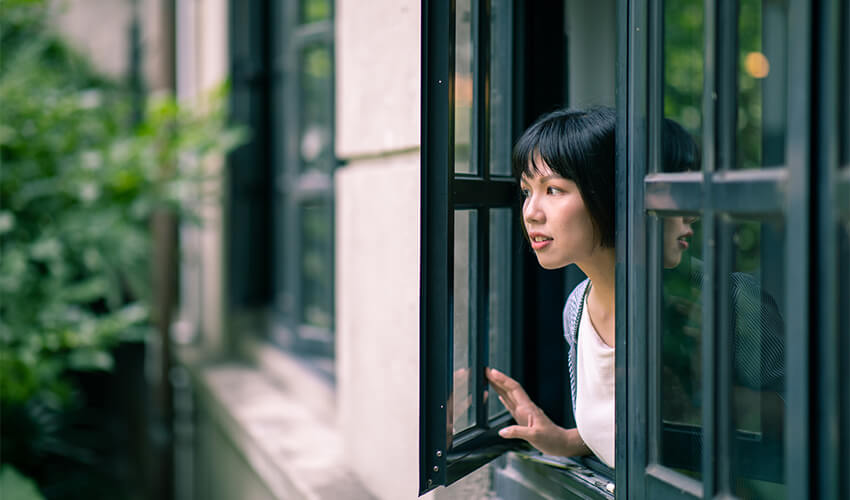 Woman opening black framed window.