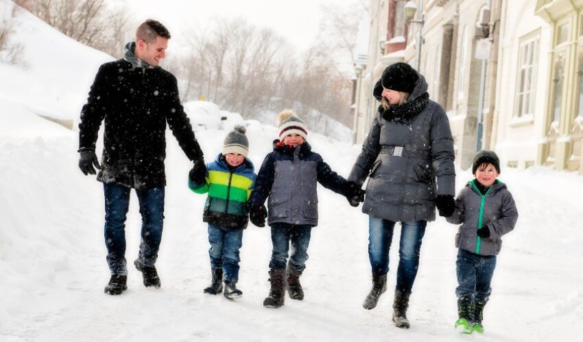 Family with three children having fun outdoors in the winter.