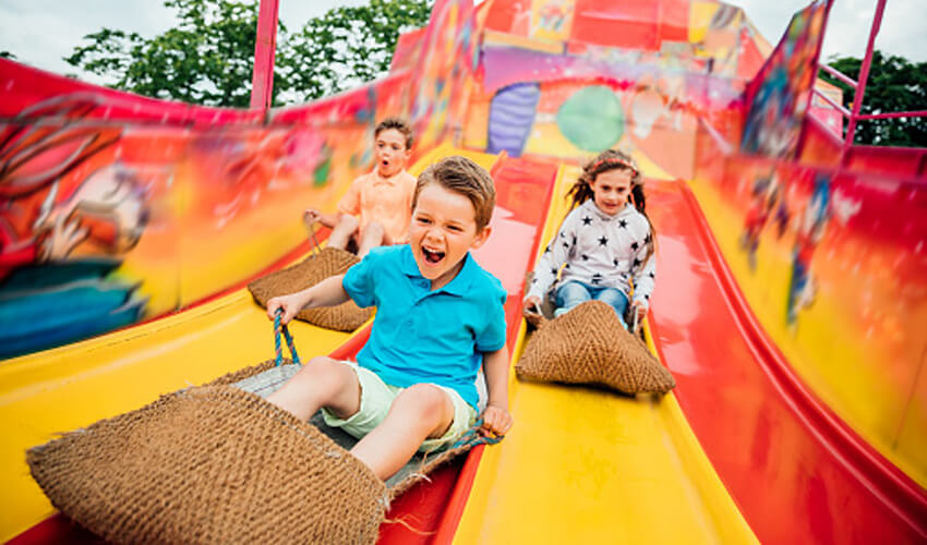 Kids sliding down a multilane slide.